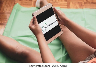 Madrid, Spain. 10-02-2021: Hands Of A Child Holding An Ipad Tablet With The BNP Paribas Logo On The Screen.