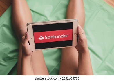 Madrid, Spain. 10-02-2021: Hands Of A Child Holding An Ipad Tablet With The Banco Santander Logo On The Screen.