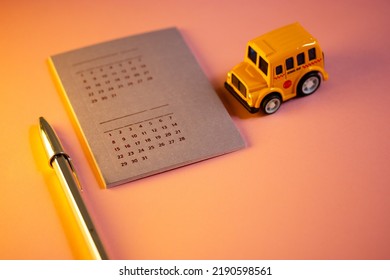 Madrid, Spain. August 1, 2022 Toy School Bus, Calendar With Different Dates, Shiny Pen - Stylish Study Tools On Pink Background In Warm Light. Back To School University In September Studying Schedule 