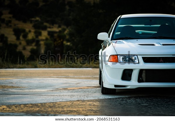 MADRID (SPAIN) August 2, 2020: View of Mitsubishi\
lancer evolution VI tommi makinen limited edition white on helipad\
at sunset.