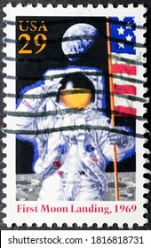 MADRID, SPAIN - AUGUST 9, 2020. Vintage Stamp Printed In USA Shows First Moon Landing In 1969, Astronaut, Usa Flag And Planet Earth