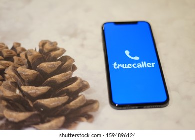 Madrid, Spain - December 21, 2019; True Caller Iphone Application On A Snow With  Pine Tree Seeds