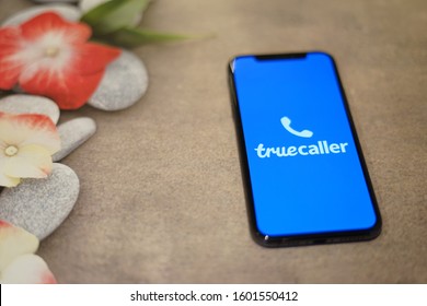 Madrid, Spain - December 30, 2019; True Caller Iphone Application On The Floor With Flowers And Rocks