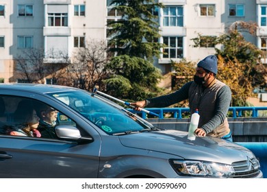 Madrid, Spain - December 6, 2021: Middle Aged Man Of South Asian Appearance Working By Washing Car Windows With A Windshield Wiper (squeegee) In Madrid, Spain. M30 Highway