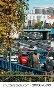 Madrid, Spain - December 6, 2021: Middle Aged Man Of South Asian Appearance Working By Washing Car Windows With A Windshield Wiper (squeegee) In Madrid, Spain. M30 Highway