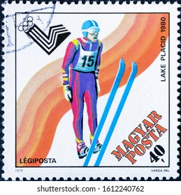 MADRID, SPAIN - JANUARY 11, 2020. Vintage Stamp Printed In Hungary Shows Ski Jumper For The 1980 Winter Olympic Games In Lake Placid