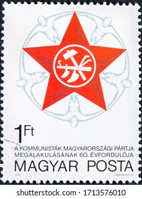 MADRID, SPAIN - JANUARY 11, 2020. Vintage Stamp Printed In Hungary Shows 60th Anniversary Of Hungarian Communist Party Emblem