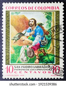 MADRID, SPAIN - JANUARY 24, 2021. Vintage Stamp Printed In Colombia Shows Isidore The Laborer Or Isidore The Farmer,  A Spanish Farmworker Known For His Piety Toward The Poor And Animal