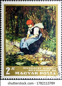 MADRID, SPAIN - JULY 20, 2020. Vintage stamp printed in Hungary shows woman carrying faggot by Mihaly Munkacsy,  a hungarian painter