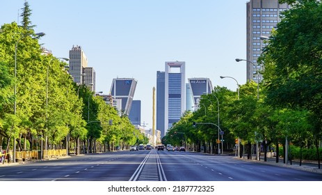 Madrid, Spain - July 30, 2022: Paseo de la Castellana in Madrid with tall company headquarters buildings and trees on the sides of the wide avenue