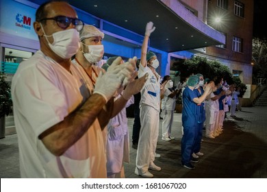 MADRID, SPAIN - MARCH 22 2020. A doctor, among medical staff from the Fundacion Jimenez Di­az hospital, waves his hand in the air to thank people back for supporting them as they fight coronavirus.