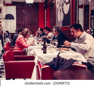 MADRID, SPAIN - MARCH 5, 2014: People Eating At Small Cafe In The City Center Of Madrid. Toned Picture