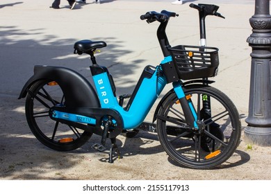 Madrid, Spain. May 1, 2022. Bird electric bike - eco-friendly transportation for riders in big city. Blue bicycle with a black basket stands on a street. Urban mobility. Modern lifestyle.