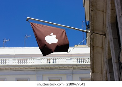 Madrid, Spain. May 1, 2022 Black Branded Flag With A Logo Of A Famous American Company Apple Inc. On A Corner Of Old Building In A Modern City. Apple Store On A Street In Urban Space. Technology Brand