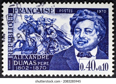 MADRID, SPAIN - NOVEMBER 30, 2021. Vintage stamp printed in France shows Alexandre Dumas (1802 - 1870) a French writer. His works include The Count of Monte Cristo or The Three Musketeers