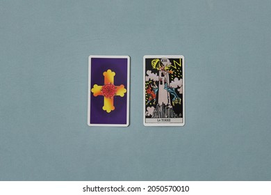 Madrid, Spain, October 1, 2021: Two Tarot Cards. One Uncovered. The Tower, Major Arcana. Background Of Light Blue, Aqua Green.