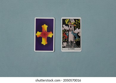 Madrid, Spain, October 1, 2021: Two Tarot Cards. One Uncovered. The Tower, Major Arcana. Background Of Light Blue, Aqua Green.