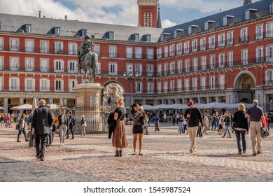 Madrid /Spain - October 14, 2019:  Young Women Explore And Take Photos On A Busy Day In Plaza Mayor, A Beautiful And Historic Plaza In Central Madrid.