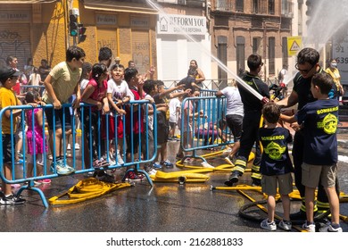 Madrid,Spain,25292022:children of different ethnicities playing in the street with water and foam thrown by firefighters at a local party