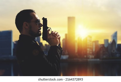 Mafia Guy Holding A Gun In A Metropolis At Sunset