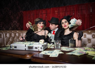 Mafia party in restaurant 1920 style. Elegant girl and man on gangster party. Mafia party in restaurant. Gangsters sitting at the table, party mafia. man and woman share the money won.