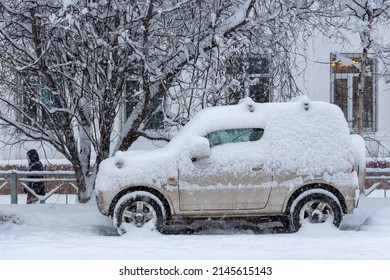 Magadan, Magadan Region, Siberia, Russia - November 8, 2021. A Snow-covered Car Parked On The Side Of A Snowy City Street. Lots Of Snow After Snowfall And Snowstorm. Cold Snowy Weather.