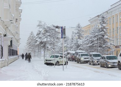 Magadan, Magadan Region, Siberia, Russia - November 8, 2021. Snow Covered City Street. A Lot Of Snow On The Roadway, Sidewalk, Cars And Trees. Cold Snowy Weather. Snowfall In The City.