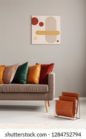 Magazine Rack Next To Beige Sofa With Pillows In Stylish Living Room Interior