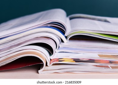 Magazines on wooden table on dark background - Shutterstock ID 216835009
