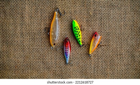 Magelang, Indonesia - October 9th 2022 : Artificial Lure Made From Plastic For Fishing By Casting. Casting Lure With Hook On The Burlap. Artificial Lure With The Shape Of Minnow - Flat Lay