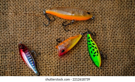 Magelang, Indonesia - October 9th 2022 : Artificial Lure Made From Plastic For Fishing By Casting. Casting Lure With Hook On The Burlap. Artificial Lure With The Shape Of Minnow - Flat Lay