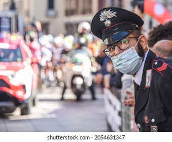 
Magenta, Italy - October 6, 2021: An Italian policeman, complete with facemask and stylish police uniform, checks the crowd before the cyclists start the Milano-Torino bicycle race in northern Italy.