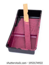 Magenta Paint And Stir Stick In Paint Roller Tray Isolated On White.