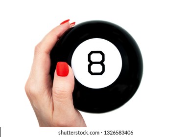 Magic 8 ball of predictions in female hand with red nails isolated on white background