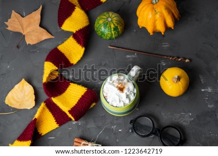 Magic autumn composition with scarf, Spicy pumpkin latte with cinnamon and autumn leaves on a black background