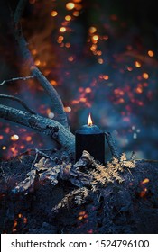 Magic Black Candle In Mystery Dark Autumn Forest, Abstract Natural Background. Fairy Scene. Witchcraft Ritual. Fall Season. Mabon, Samhain Sabbat, Halloween Holiday Concept