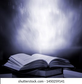 Magic book, abstract blue light on a wooden background