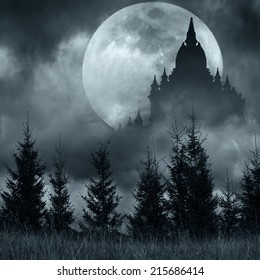 Magic castle silhouette over full moon at mysterious night. Fantasy background with pine tree forest under dramatic cloudy sky 