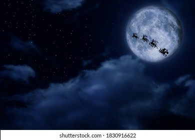 Magic Christmas eve  Santa and reindeers flying in sky full moon night