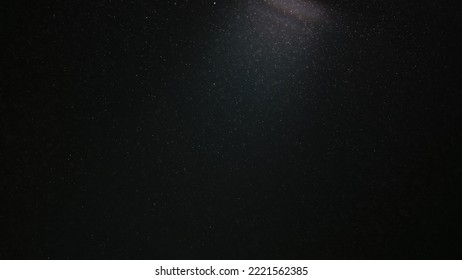 A magic cloud of dust floating in space on a black background. Particles sparkle and shimmer in studio light. Macro shot of texture whites snow, smoke, steam, fog with glare luminosity. - Shutterstock ID 2221562385