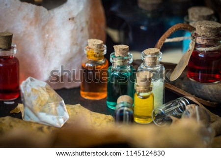 Magic concept. Potions in bottles, candles, box and orange leaves. Magical background