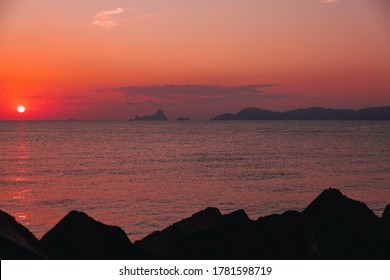 The magic, famous rock of Es Vedra, Ibiza, from the port of Formentera. Ibiza's most popular icon and symbol, said to be magic and mysterious. Sun going down, red sunset light.