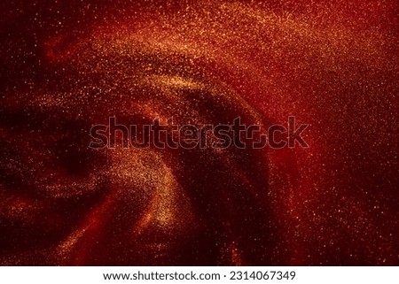 Magic galaxy of golden dust particles in red fluid. Gold particles sparkling stains in overflows on red. Abstract shiny glittering background.
