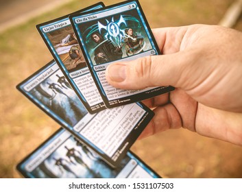 Magic: the Gathering, MTG. Man holding some playing cards. The letter highlighted: Bond of insight. Brasilia, Federal District - Brazil. October, 14,  2019.