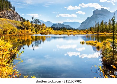 The magic of northern "Indian summer". Lake Vermillon among the yellow fall grass. Grandiose landscape in the Rocky Mountains of Canada. 