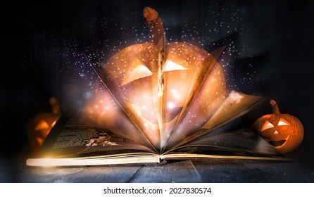 Magic open book which lights up and shines.Wizard story book with glowing stars and burning orange pumpkins on the dark halloween background.Turn pages and do spell. Jack o lantern on the wooden table