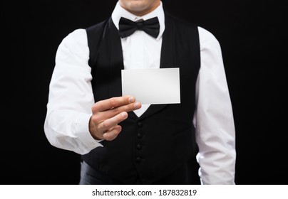 Magic, Performance, Circus, Casino And Show Concept - Casino Dealer Holding White Card