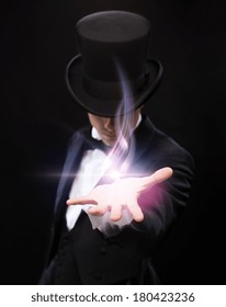 Magic, Performance, Circus, Show And Advertisement Concept - Magician Holding Something On Palm Of His Hand