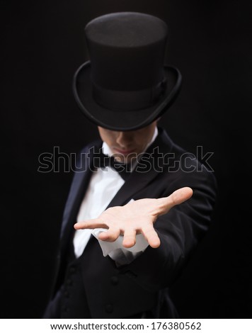 magic, performance, circus, show and advertisement concept - magician holding something on palm of his hand