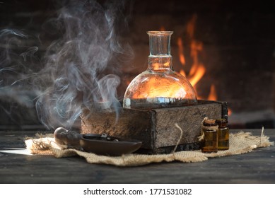 Magic potion on the table on burning fire in fireplace background. Alchemy concept.